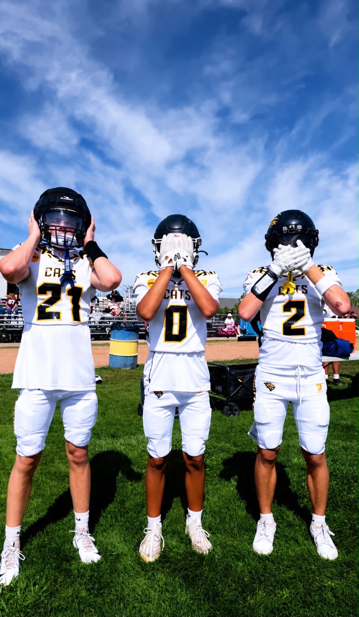 Three Sabercats players posing together in white uniforms